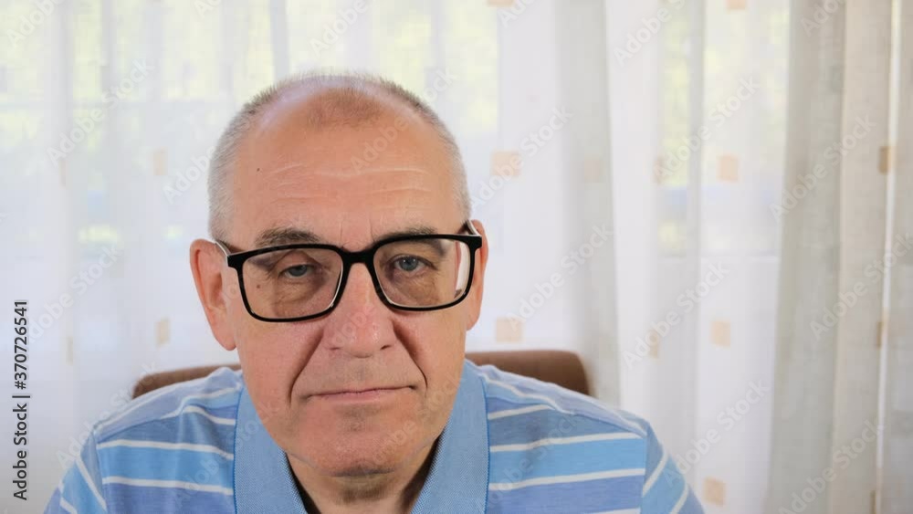 middle-aged man with glasses smiles and then looks sternly and frowns middle-aged man with glasses smiles and then looks sternly and frowns