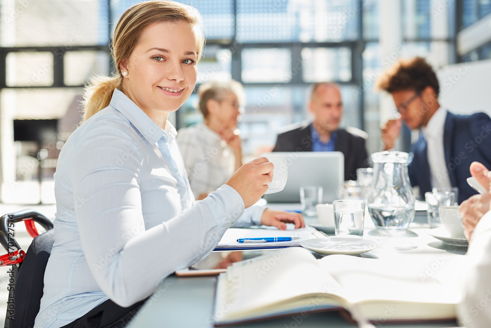 Frau im Rollstuhl trinkt Kaffee in einem Meeting Frau im Rollstuhl trinkt Kaffee in einem Meeting