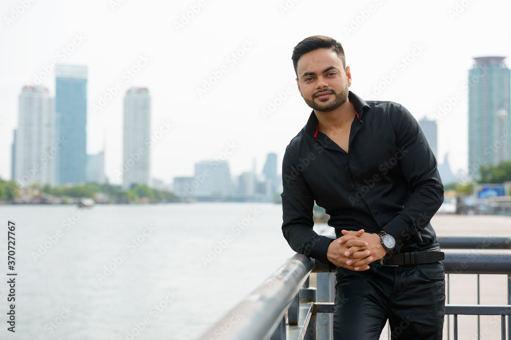 Young handsome bearded Indian businessman in the city Young handsome bearded Indian businessman in the city