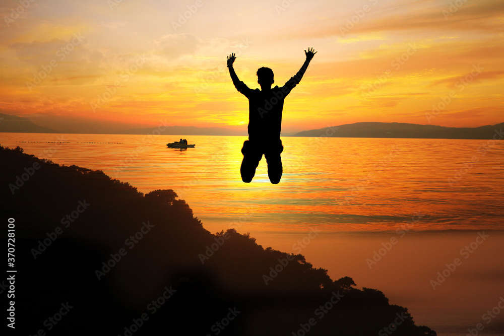 silhouette of man jumping on the beach
