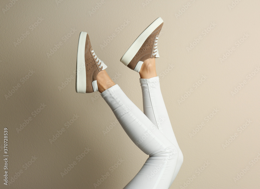 Woman wearing shoes on beige background, closeup - obrazy, fototapety, plakaty 