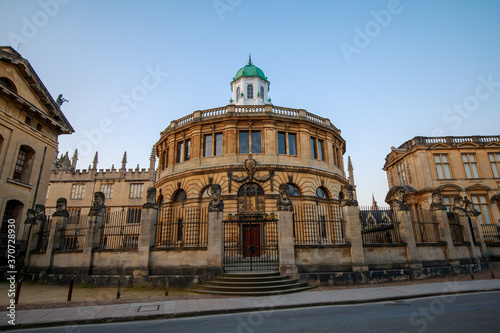 The Sheldonian Theatre and the statues around it, from Broad Street in Oxford with no people. Early in the morning. Oxford, England, UK.