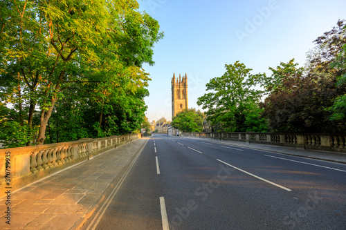 Magdalen Bridge and Magdalen Tower in Oxford at sunrise with no people around, early in the morning on a clear day with blue sky. Oxford, England, UK.