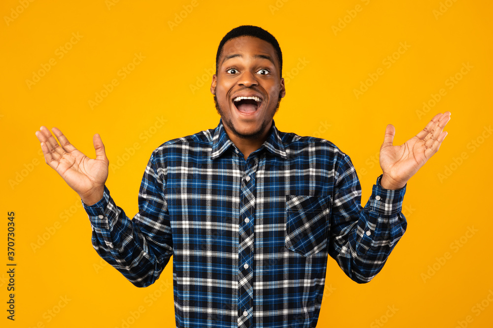 Surprised African Guy Posing With Opened Mouth Over Yellow Background