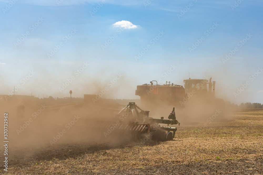 Fototapeta premium The tractor plows the land. Agriculture image