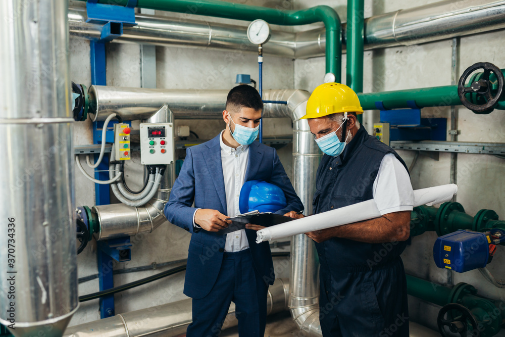 industry worker and his manager discussing in plant. safety face mask due covid virus industry worker and his manager discussing in plant. safety face mask due covid virus