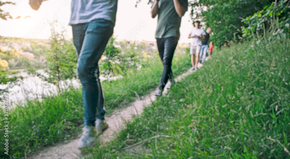 Blurred view of friends are walking through the pathway on the hill Blurred view of friends are walking through the pathway on the hill