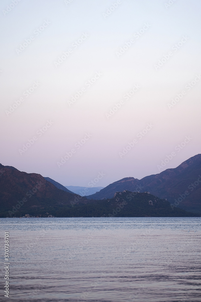 Vertical photo of sea and hills in dusk. Traveling to nature