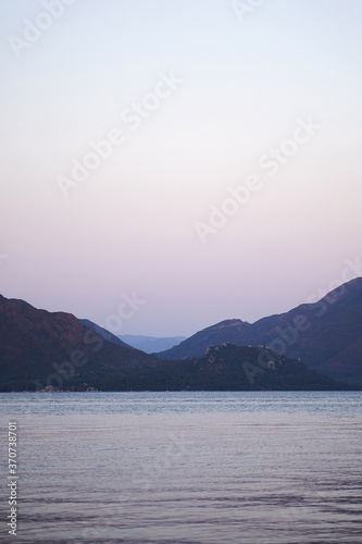 Vertical photo of sea and hills in dusk. Traveling to nature