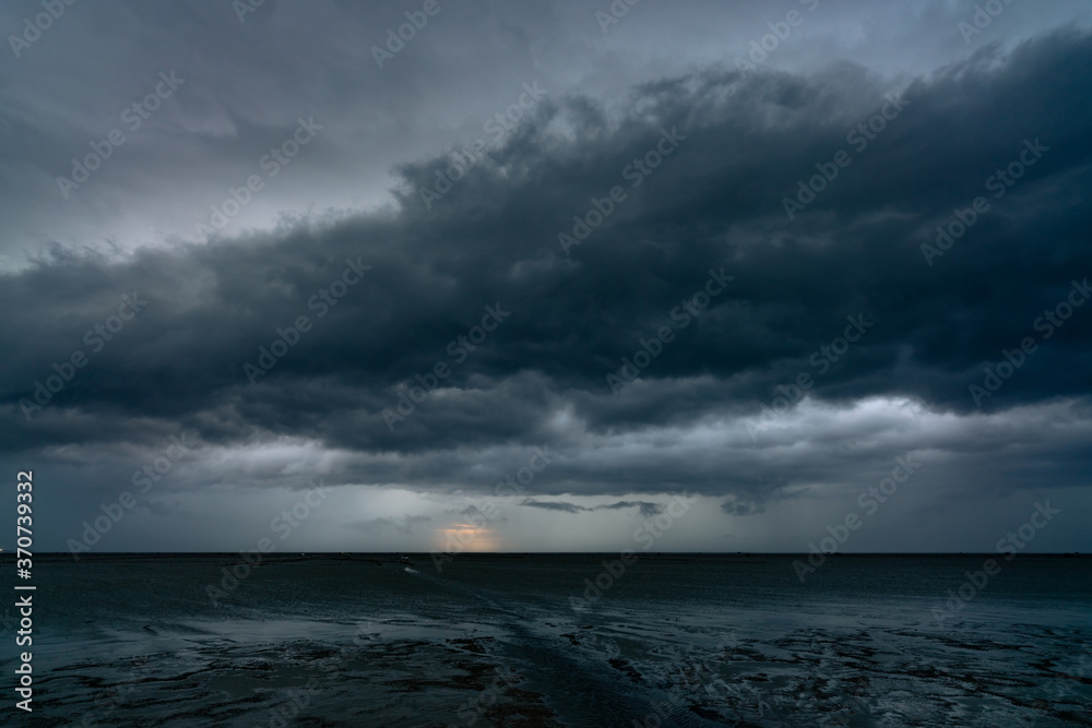 Landscape view of sea at tide and silhouette dark dramatic sunset sky and clouds in the evening. Sunset sky of tropical beach. Beauty in nature. Dark background for sad, death, and depression. Landscape view of sea at tide and silhouette dark dramatic sunset sky and clouds in the evening. Sunset sky of tropical beach. Beauty in nature. Dark background for sad, death, and depression.