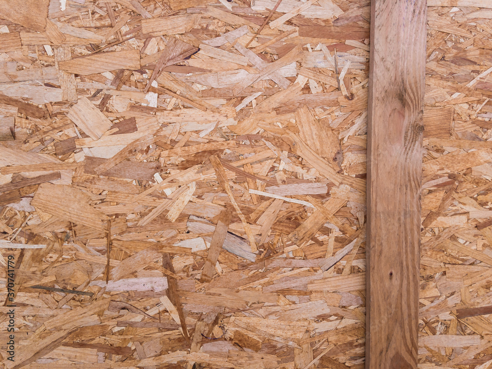 Background image. The textured surface of OSB wood board and wood slats in natural light. Background image. The textured surface of OSB wood board and wood slats in natural light.