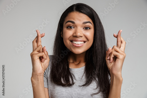 Beautiful african woman with fingers crossed isolated