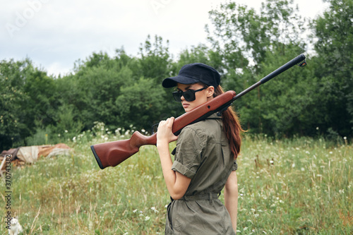 Military woman Fresh air travel with a gun on his shoulder black cap green 