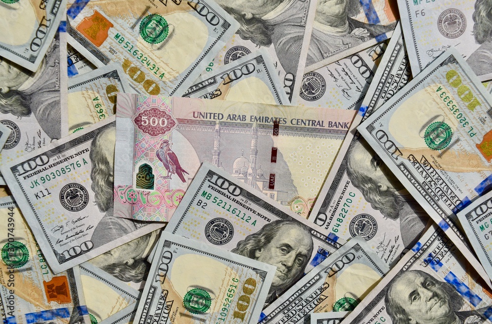 Foto de UAE national banknote on top of USA national currency, top view