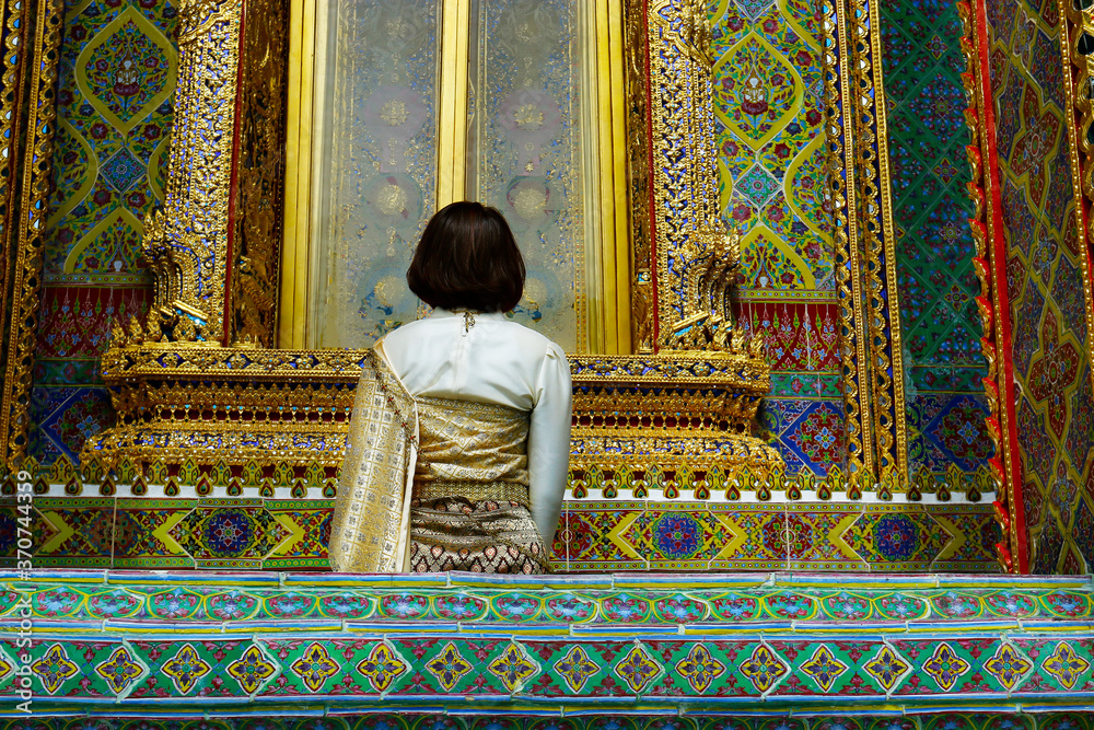 Fototapeta premium woman with traditional clothes in the buddhist temple rachabopit in the city of bangkok -thailand