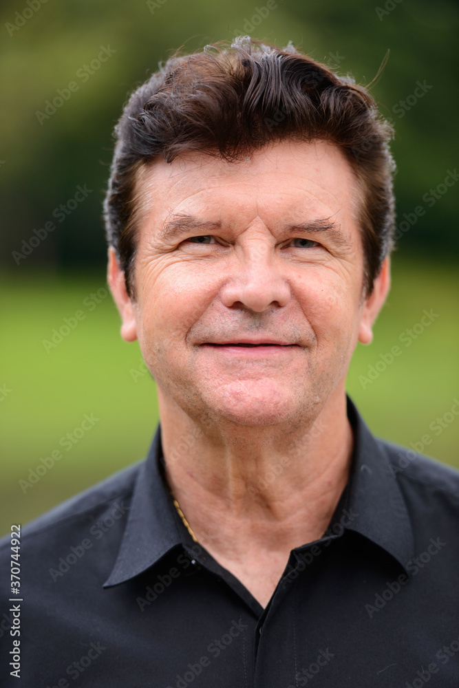 Portrait of happy mature handsome businessman relaxing at the park Portrait of happy mature handsome businessman relaxing at the park