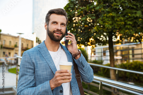 Confident young man holding coffee cup