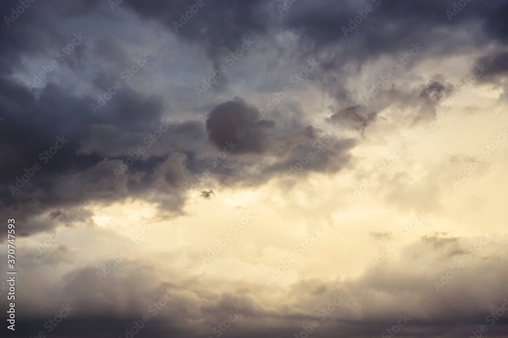 Beautiful evening cloudy sky. Gray sky with warm light Beautiful evening cloudy sky. Gray sky with warm light