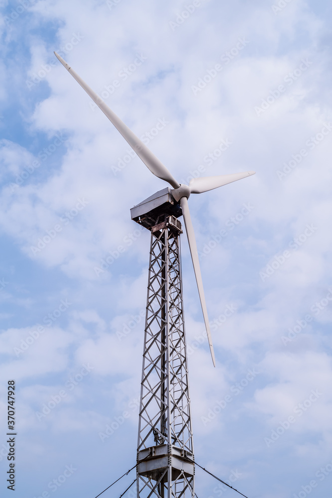 Wind turbine tower on the metal truss against cloudy sky. The picture was taken in Russia, in the Orenburg region, in the countryside Wind turbine tower on the metal truss against cloudy sky. The picture was taken in Russia, in the Orenburg region, in the countryside