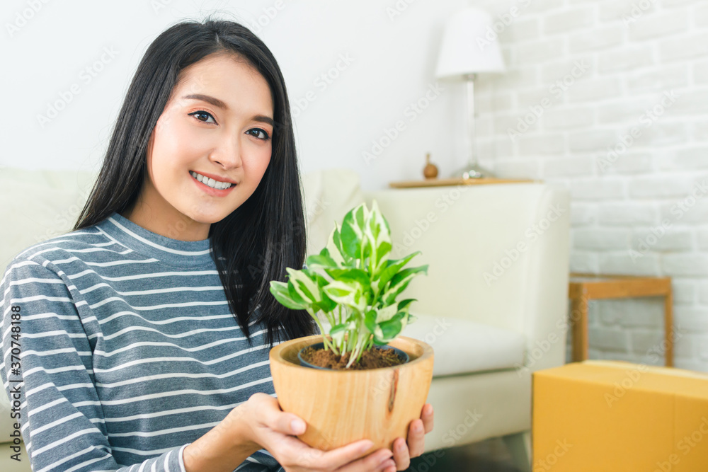 Beautiful young asian and friend happy holding tree from boxes smiling excited moving to a new home Beautiful young asian and friend happy holding tree from boxes smiling excited moving to a new home