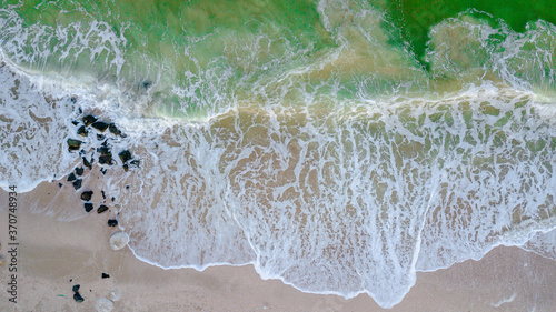 Aerial panoramic drone view of beautiful ocean waves and sand beach