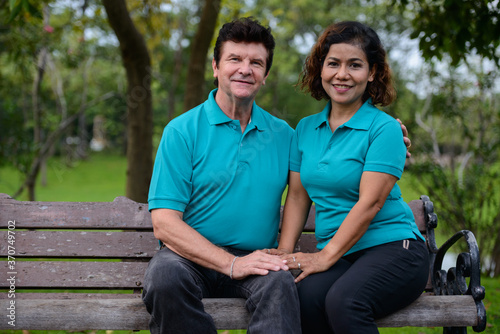 Happy mature multi ethnic married couple together and in love at the park © Ranta Images