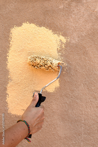 Hand painting wall with cream roller vertical