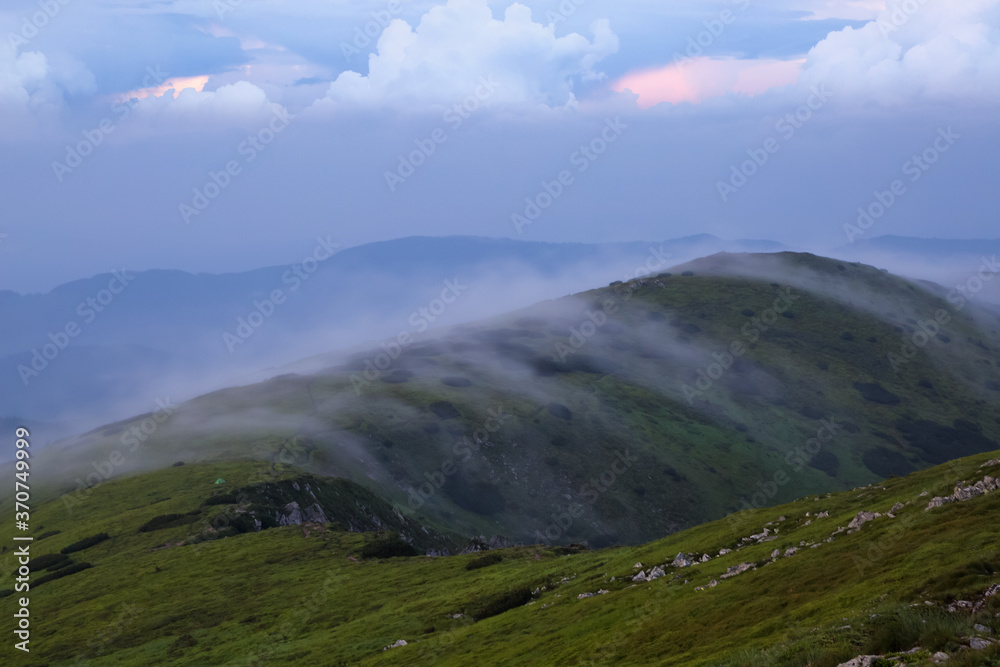 Landscape with high mountains. Amazing foggy summer morning. The early morning mist. A place to relax in the Carpathian Park, Ukraine, Europe. Natural landscape. Free space for text.