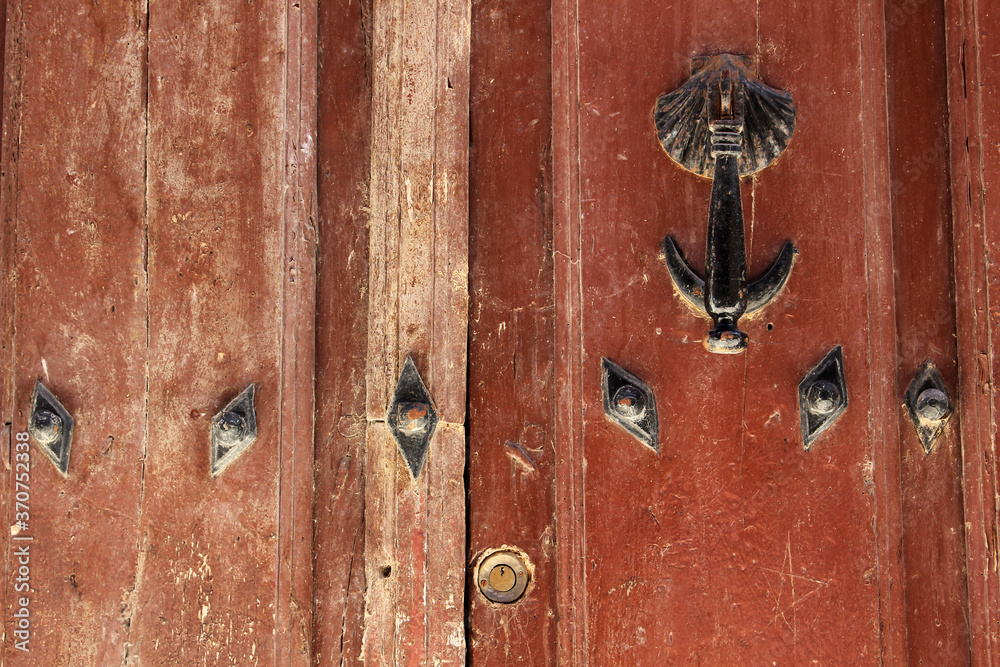 Old wooden door with knocker and metal details