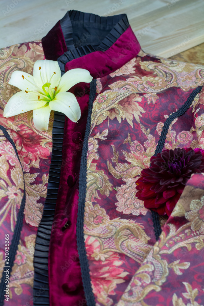 dunkelrote jacke aus samt und seide mit blumendekor bestehend aus einer weißen lilienblüte und einer roten dahlienblüte