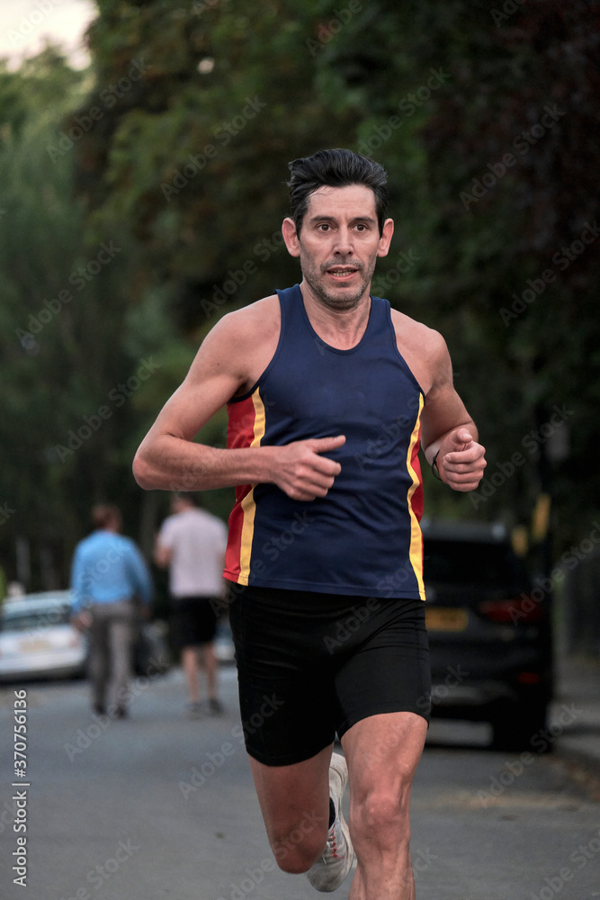Runner. A man in sports outfit runs along the street. Runner. A man in sports outfit runs along the street.