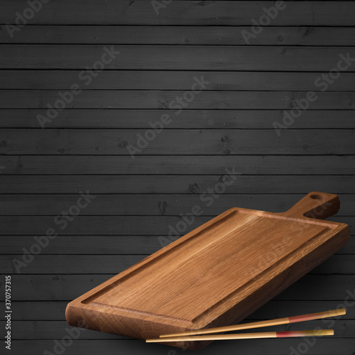 Empty serving board close-up on a wooden background. Chopsticks lie nearby. Place to place Asian food.