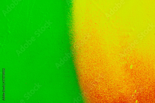 Beautiful bright colorful street art graffiti background. Abstract creative spray drawing fashion colors on the walls of the city. Urban Culture  yellow  green   sunny  orange  ginger texture
