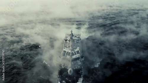 Drone shot of navy ship on foggy sea, centered