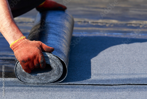 Worker puts roofing material
