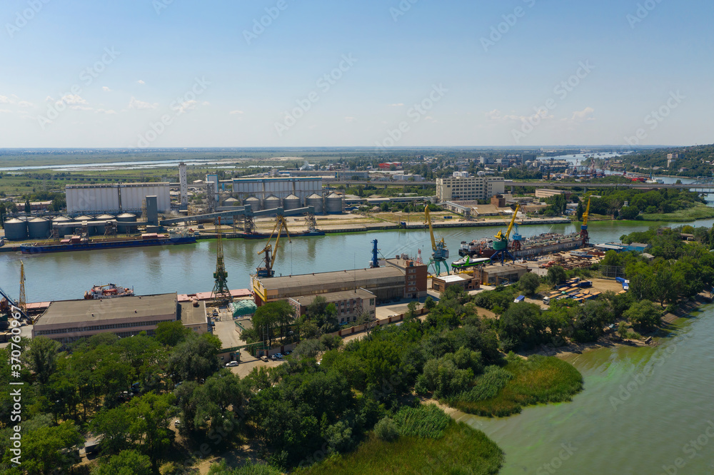 Ships and cranes in the river port. Aerial view.