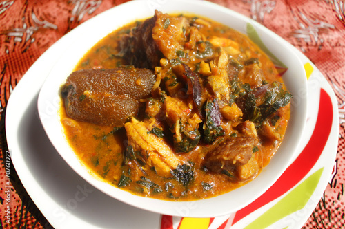 Close up of a bowl of ogbono soup. This is a popular Nigerian dish usually served with other foods to swallow. It contains beef, dried fish, chopped meat pieces, kpomo and little vegetable photo