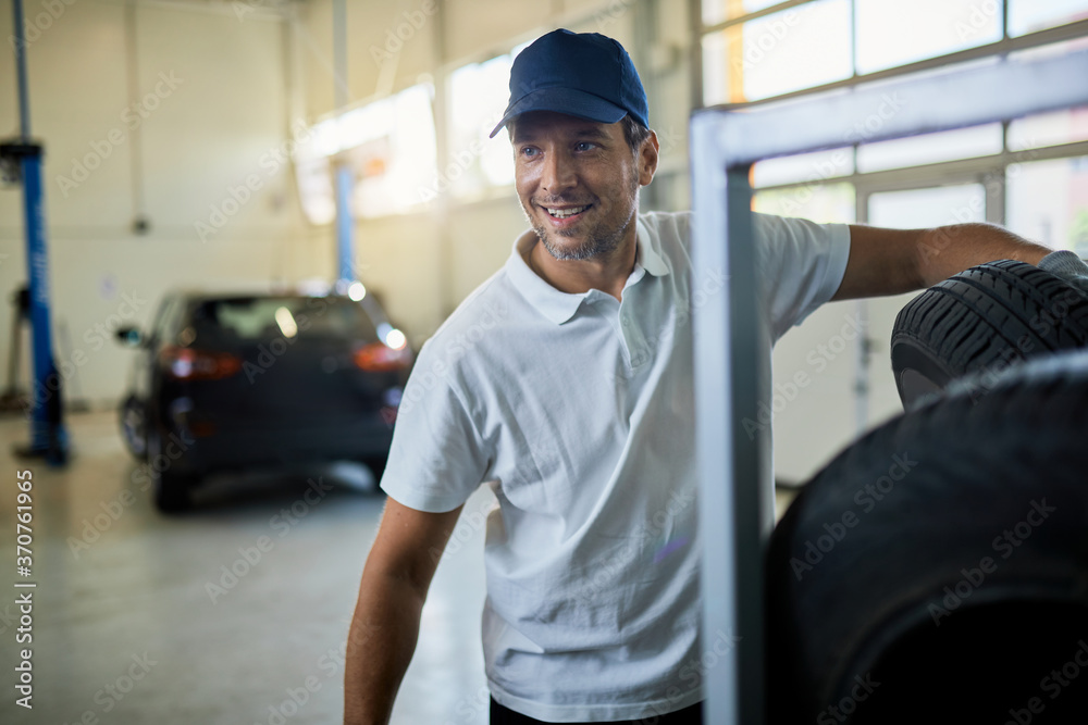 Happy car mechanic working in auto repairs shop. Happy car mechanic working in auto repairs shop.