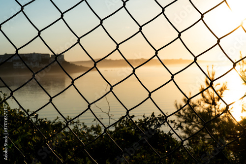 View of the river to the sea through a fence