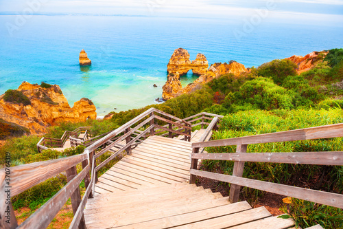 Beautiful shore of Atlantic ocean with stairs to the beach. Algarve, Portugal. Famous travel destination.