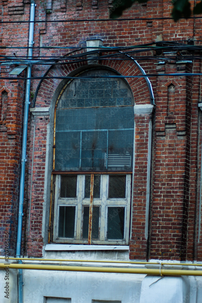 Antique stained glass window on an old red brick building Antique stained glass window on an old red brick building