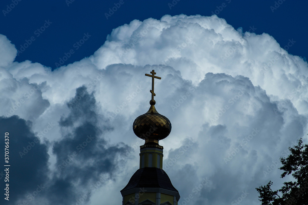 Beautiful Golden Church dome on the background of storm clouds illuminated by the sun. The Church landscape. Dome of an Orthodox Church
