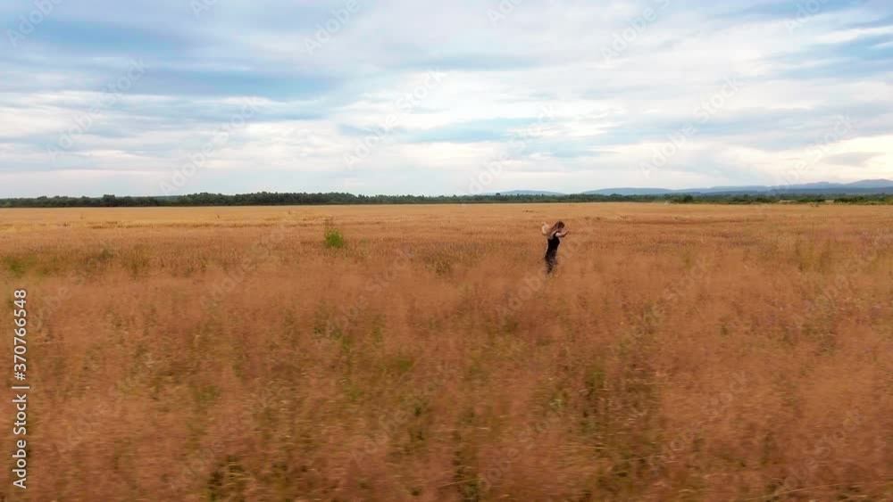 Ending quarantine, a cheerful girl runs in the field and takes off his mask, flying sideways by helicopter Ending quarantine, a cheerful girl runs in the field and takes off his mask, flying sideways by helicopter
