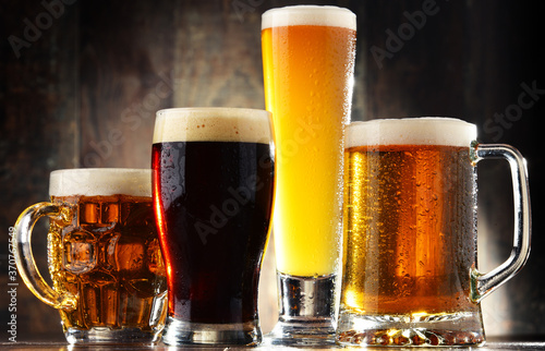 Four glasses of beer on wooden background