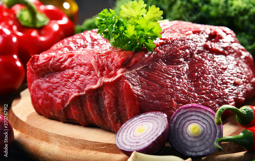 Piece of beef and spices on cutting board photo