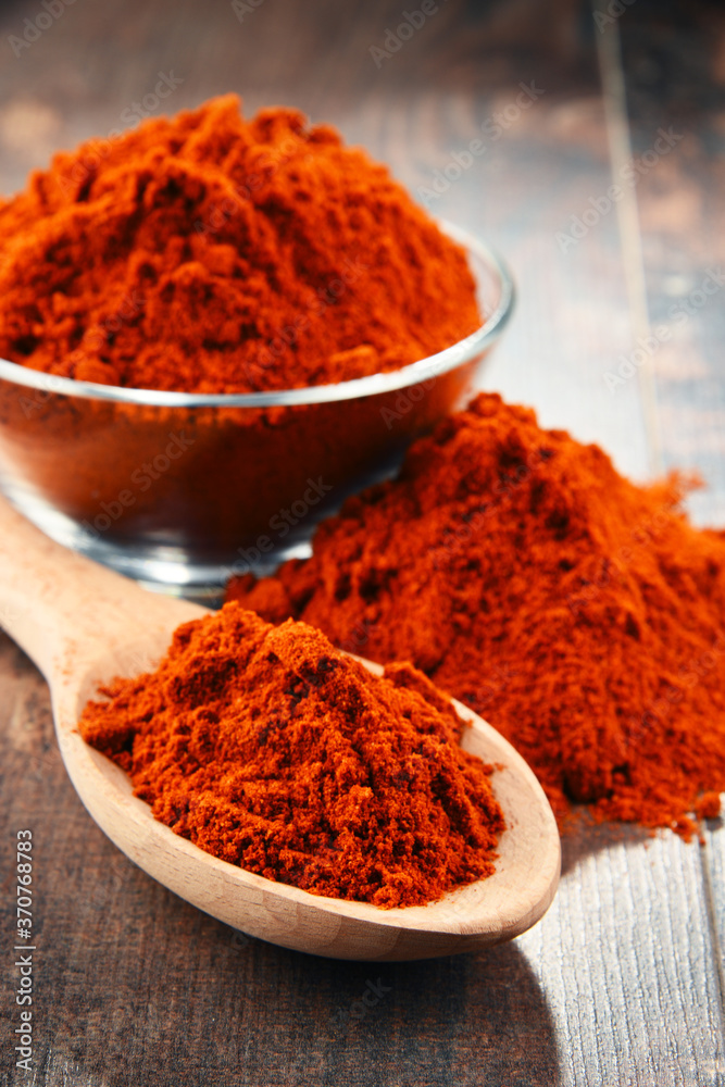 Composition with bowl of chili powder on wooden table Composition with bowl of chili powder on wooden table