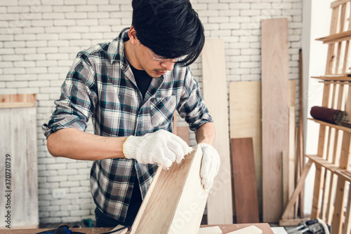 Carpenter Man is Working Timber Woodworking in Carpentry Workshops, Craftsman is Applying Glue to Timber Plank for Wooden Furniture in Workshop. DIY Workmanship, Job Carpenters Concept