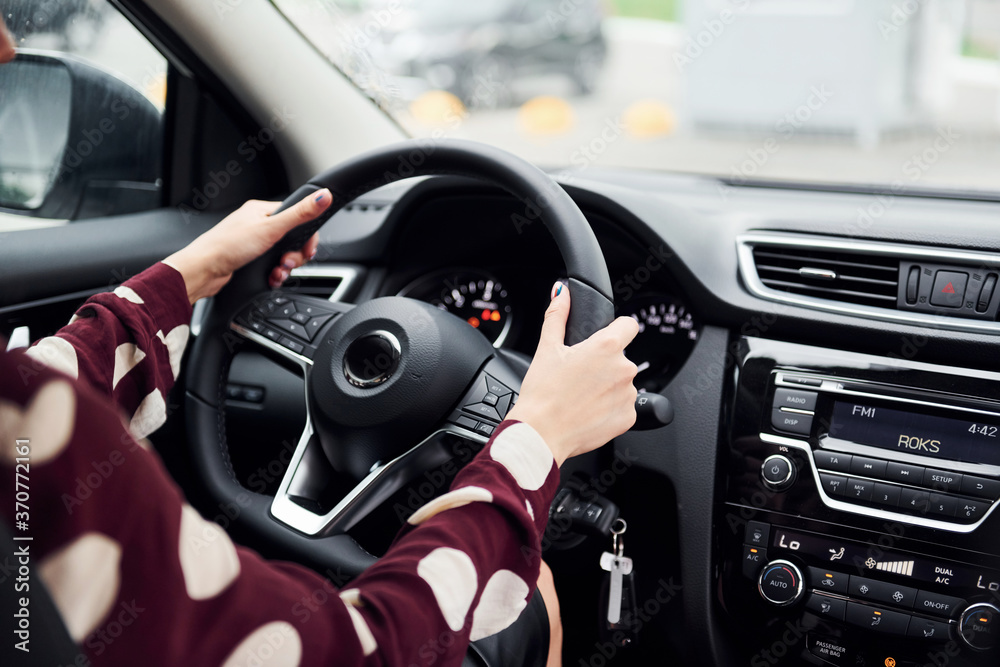 Close up view of beautiful young brunette that inside of modern automobile. Riding car