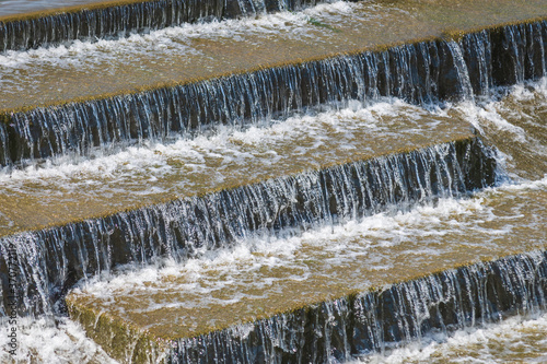 Closeup shot of a waterfall flowing over stone steps.