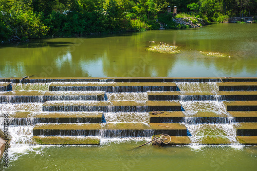 Waterfall down stone steps with a discarded bicycle at the bottom.